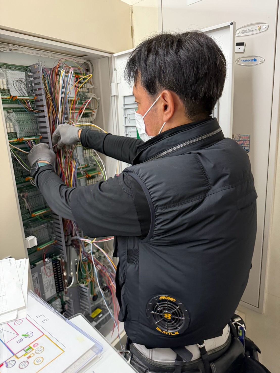 手元の資料を確認しながら受信機の配線を進める作業